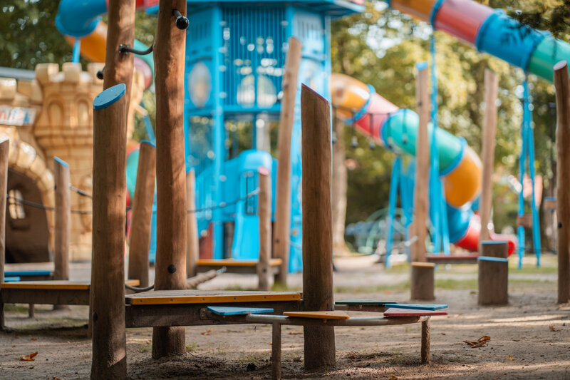 Buitenspelen in speelpark Sprookjeshof, omringd door groen en speeltoestellen, met een vrolijke en kindvriendelijke uitstraling. 