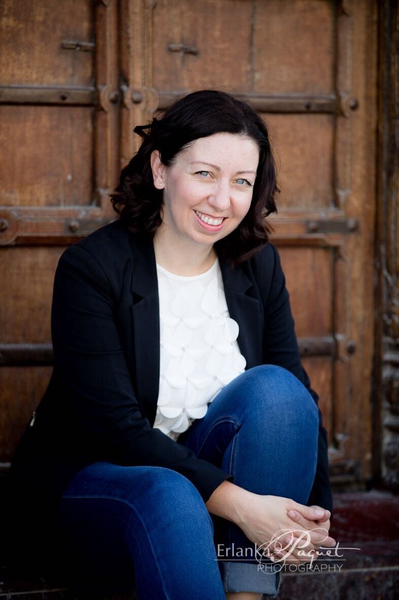 Show thumbnail preview	 A woman with dark hair, wearing a black blazer and blue jeans, sits against a wooden door, smiling with the confidence of post-secondary leadership.