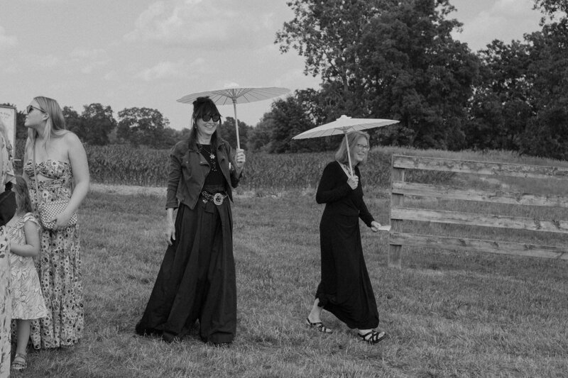 Wedding guests walking with small umbrellas 