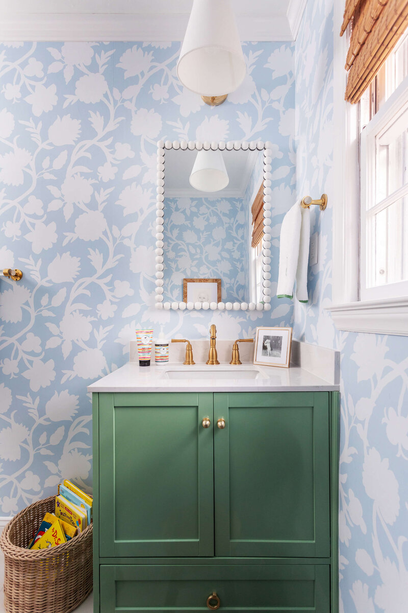 Colorful wallpapered bathroom with green sink