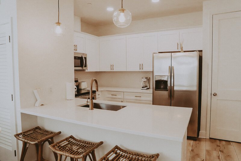 kitchen with marble counters and rattan bar stools