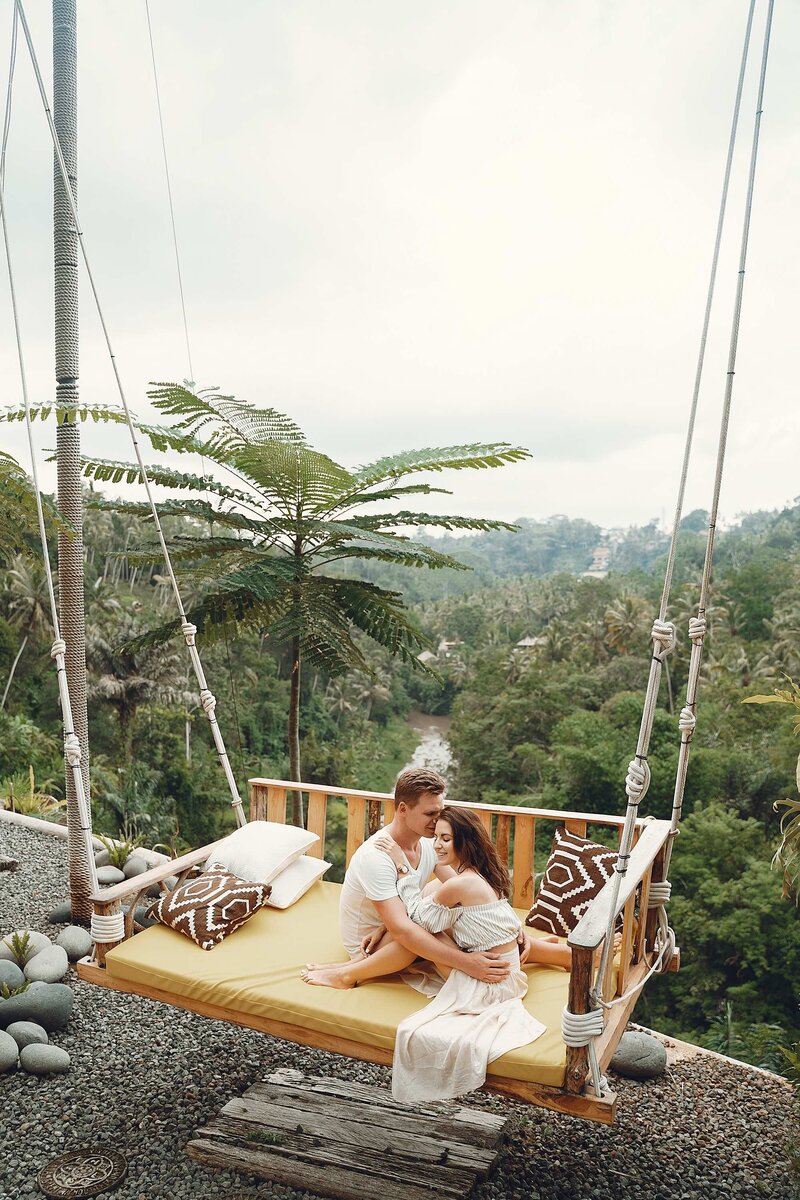 happy couple on outdoor swing in jungle of Bali