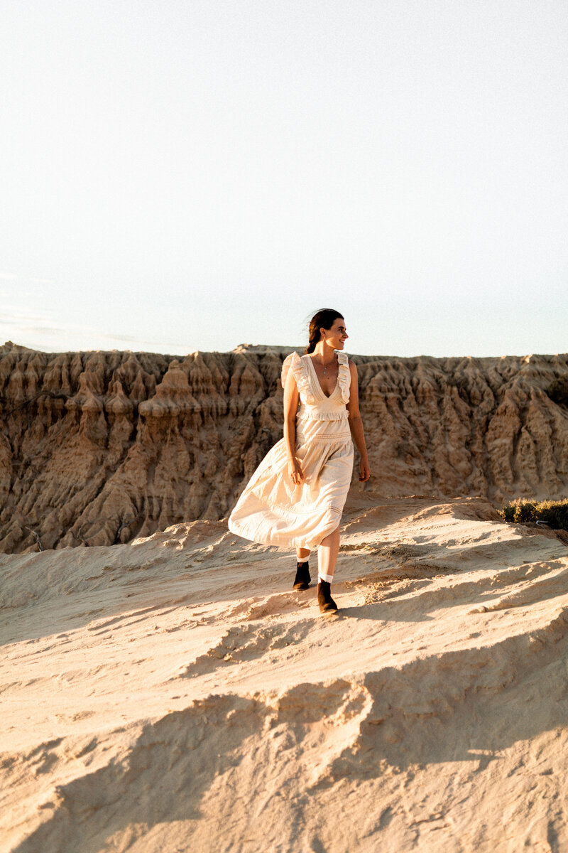 woman walking through the australian desert in a white dress