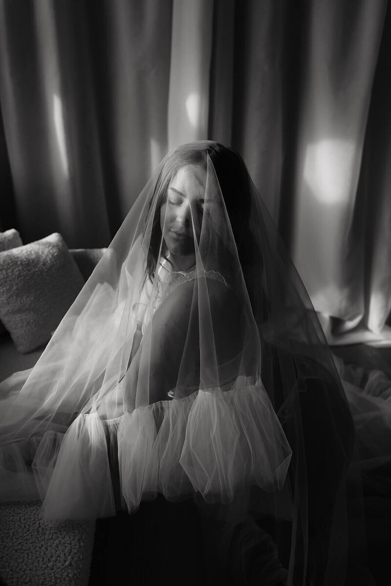 Bride looks down seductively with veil covering her face