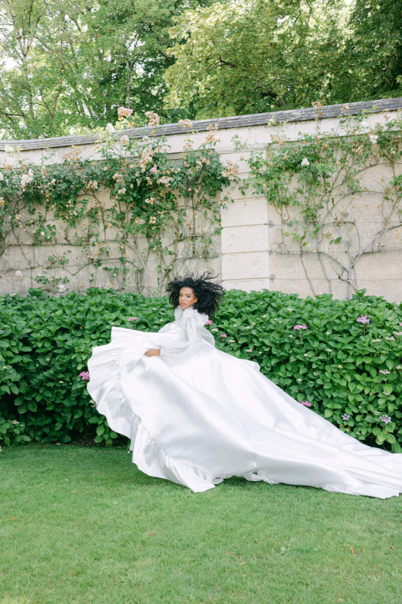 Bride posing for a photo in the gardens of chateau du grand luce during her wedding