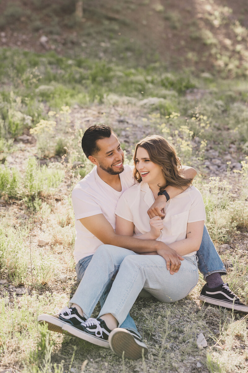 couple snuggling for engagement photos in a field on mt charleston in las vegas