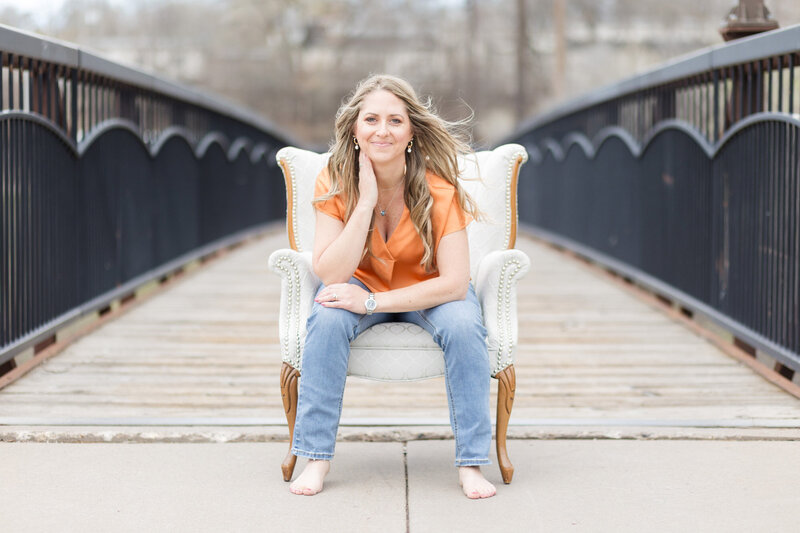 Amy sitting in a chair on a bridge