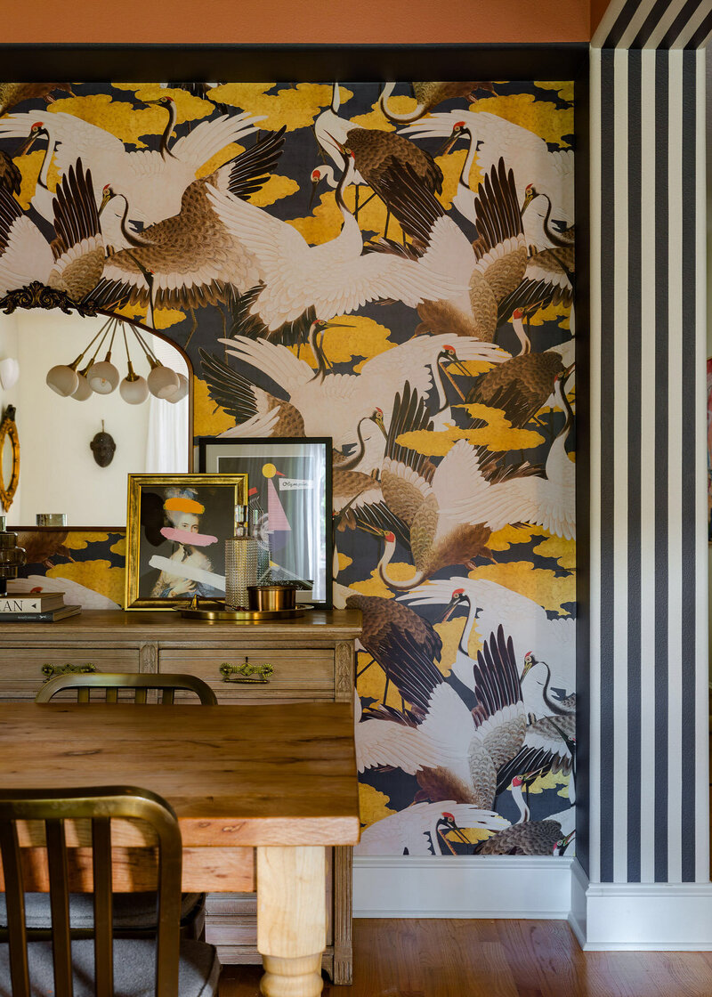 Playful and bold wall paper with flying birds with a table and mirror in front, representing the eclectic work of an interior designer in Portland Oregon. 