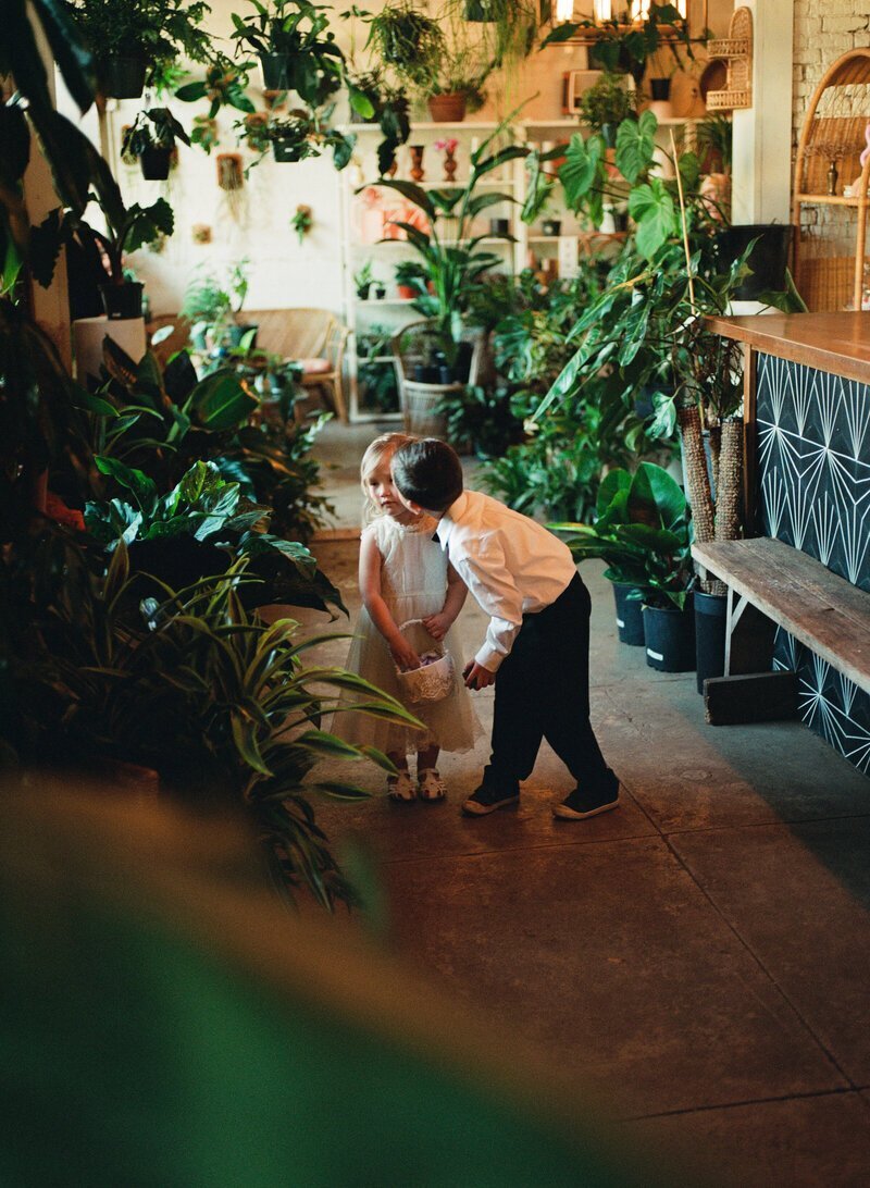 Little kids in a greenhouse by film wedding photographers Noble Photo Co