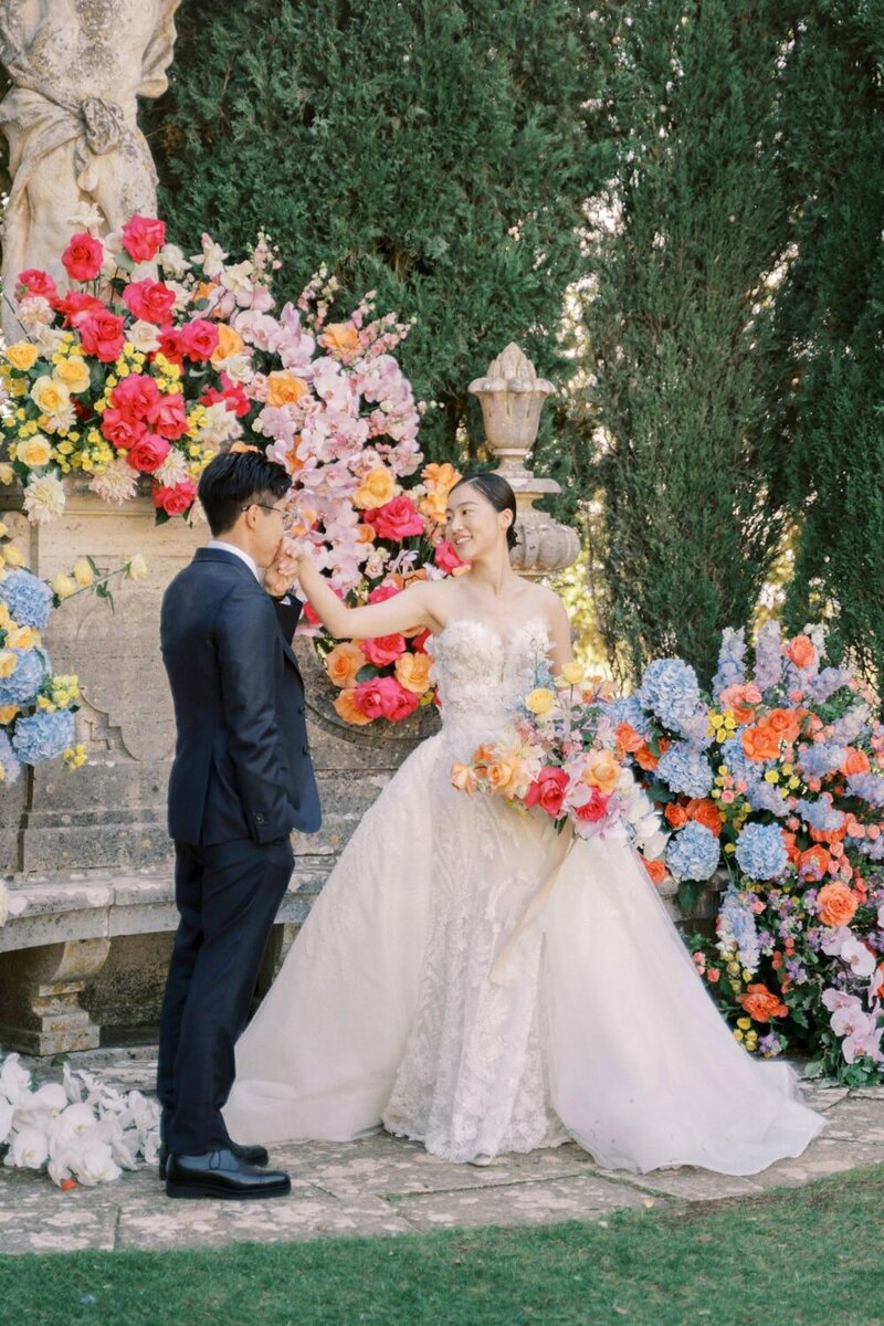 Couple embracing in front of ceremony flowers at their la Foce Wedding in val d' orcia, captured by renowned Tuscany photographer Andreas K. Georgiou
