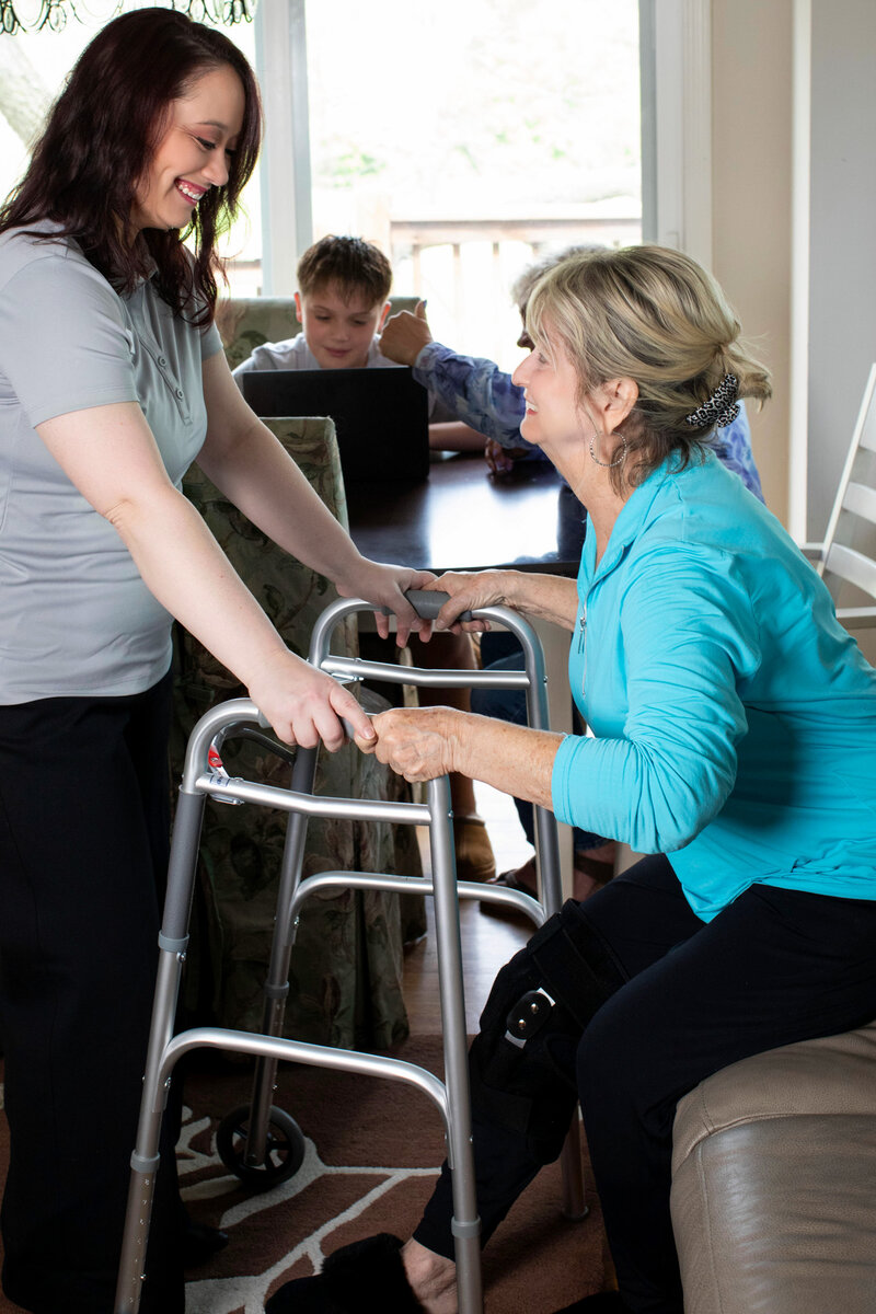 Caregiver helping senior woman with mobility 