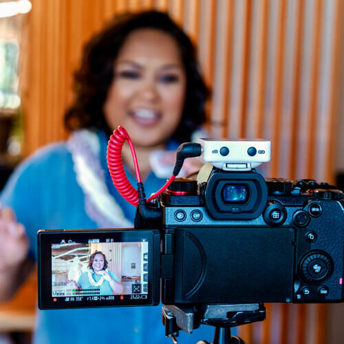 Photo of Koko Mendez, Founder of Mendez Modern Media, in front of a camera