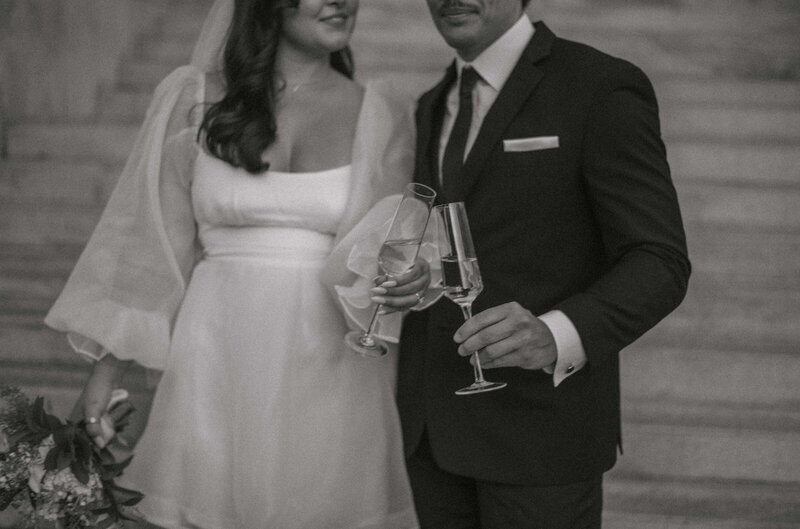 bride and groom clinking glasses after eloping at city hall
