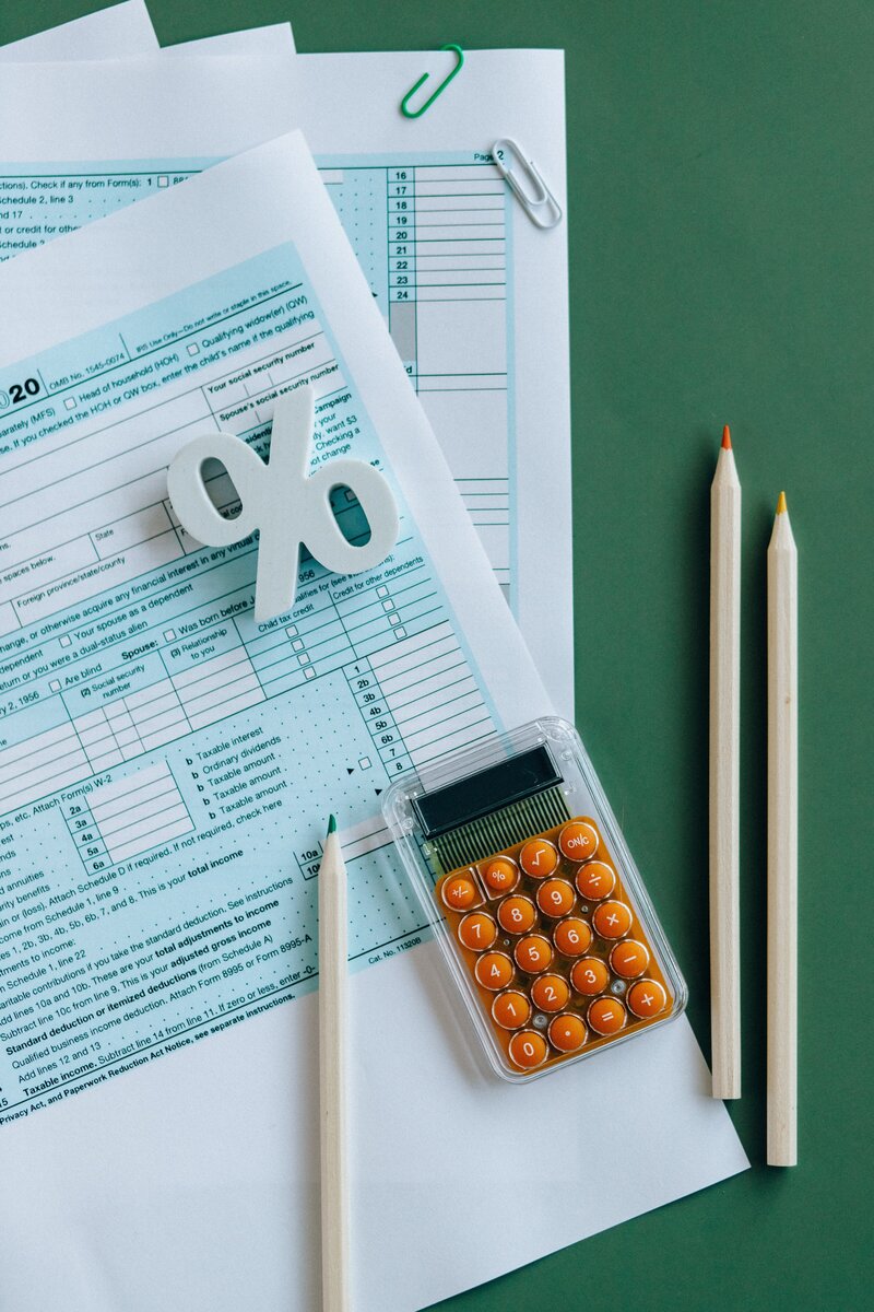 Tax from and green calculator with colored pencils