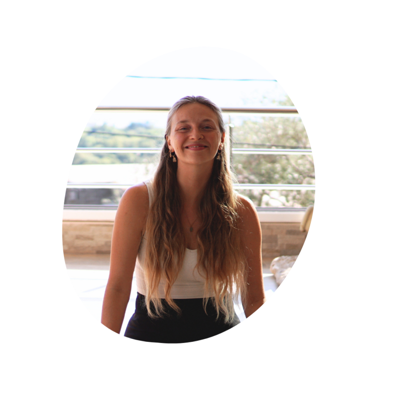 Women in white dress sitting on stairs by the beach