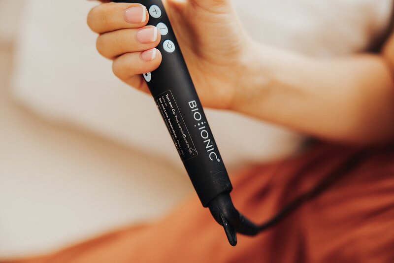 Detail photo of Caitlin holding a curling iron