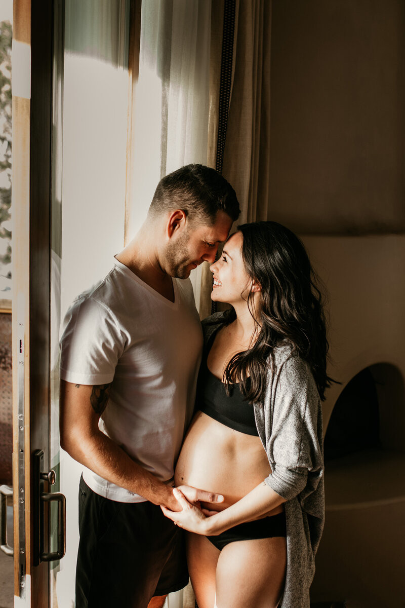 pregnant woman and husband looking at each other smiling