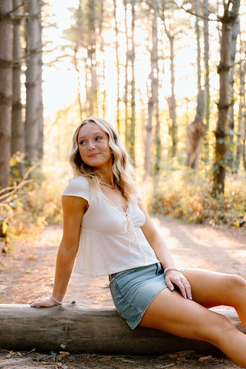 girl poses in forest for senior photos