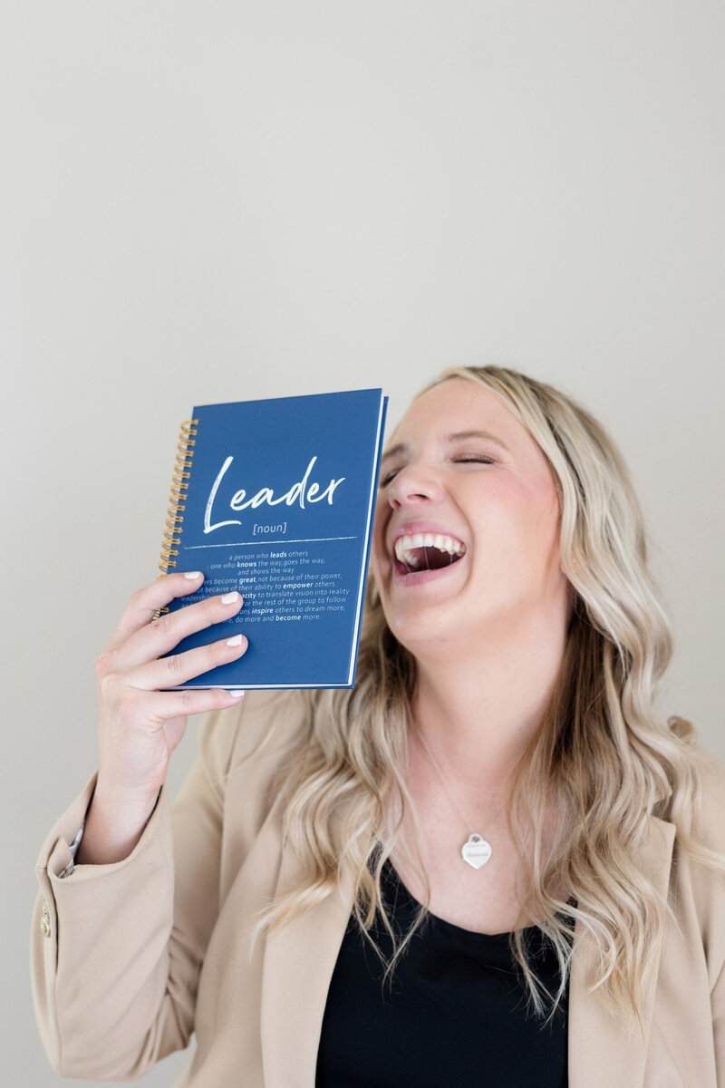 Becca playfully holding a book up to her face