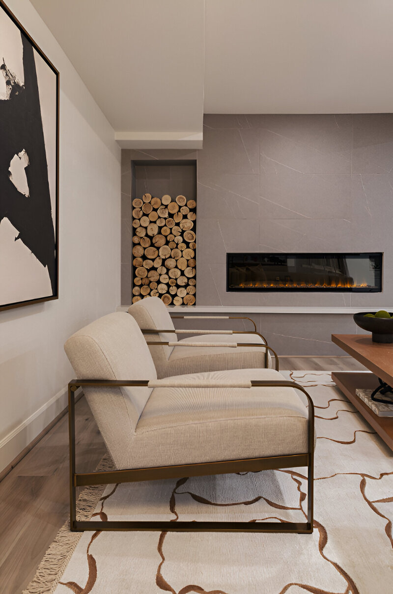 Wide shot of a modern living room with a stone fireplace, modern metal chairs and textured furnishings in this Park City remodel by Sister Studio