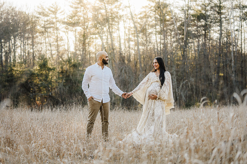 woman in cream lace maternity dress gets photos taken in boston