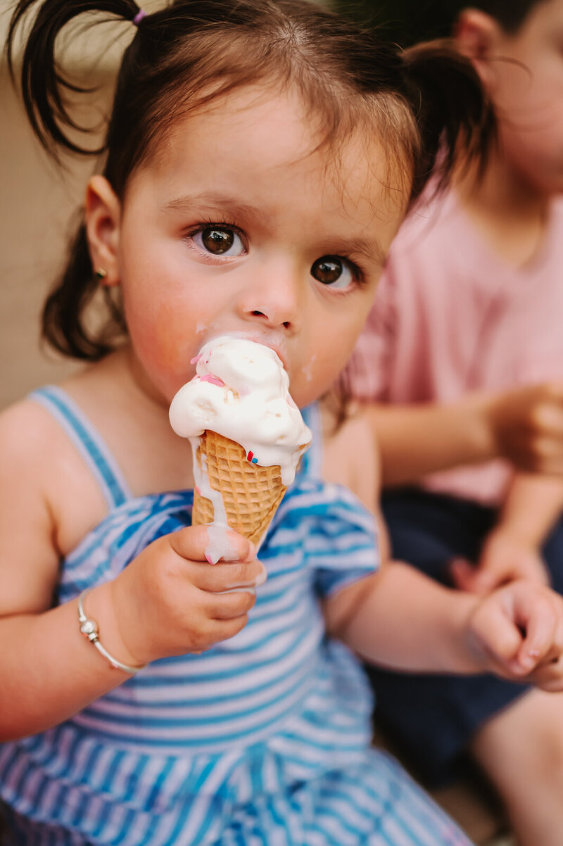 Girls wearing blue jump suit eating ice cream for Boston Portraits