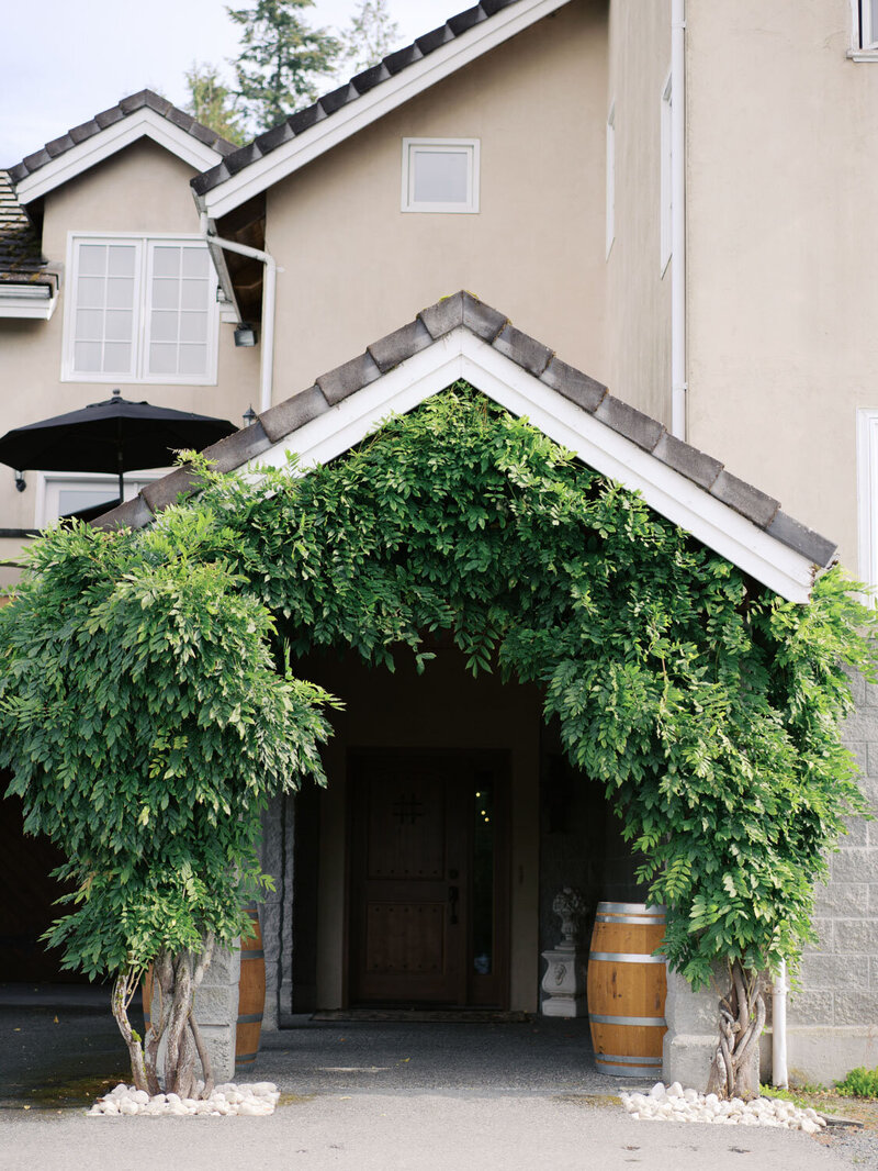 Venue entryway covered in vibrant green wisteria