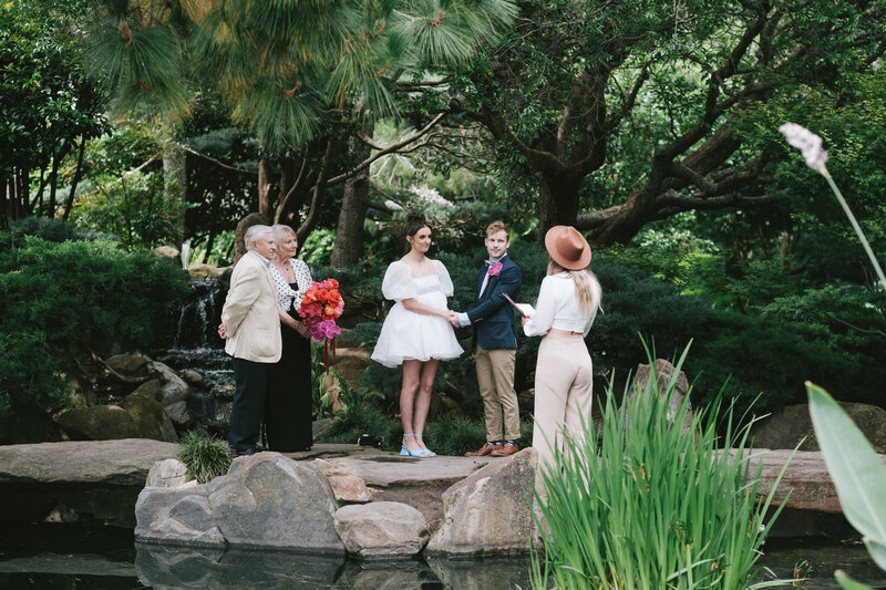 Bride and groom eloping in Garden with parents