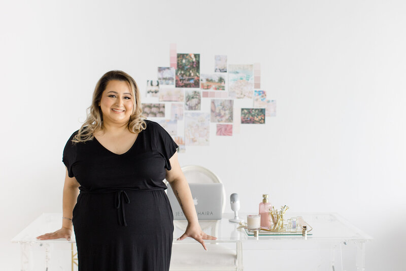 Jessie Khaira, luxury sikh wedding planner smiling at her desk looking at her laptop