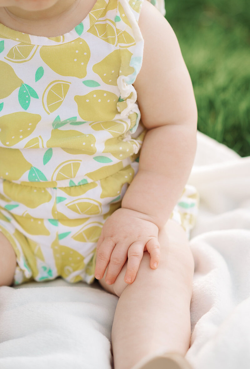  Close-up of baby in lemon romper during outdoor milestone session – Harrisburg, PA photography