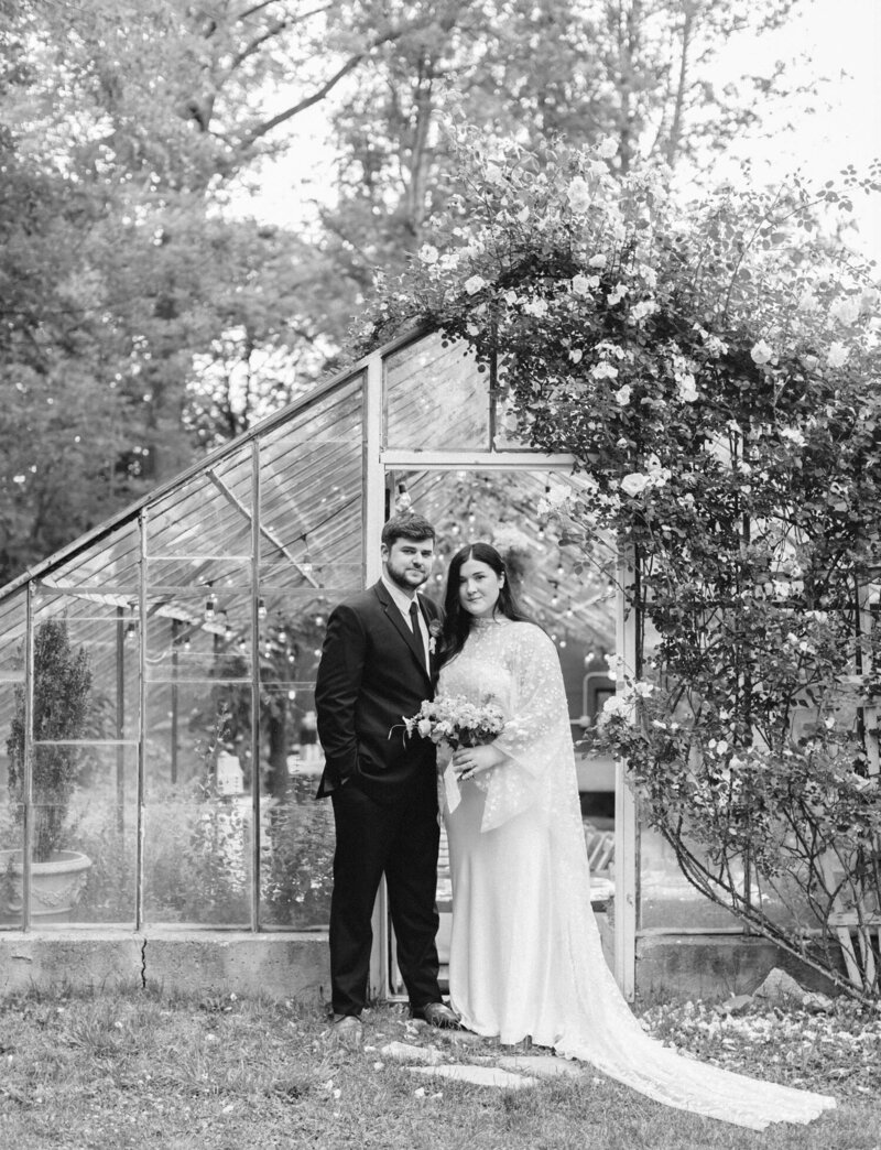 newlywed couple, bridal cape at glass house greenhouse wedding venue, Michigan