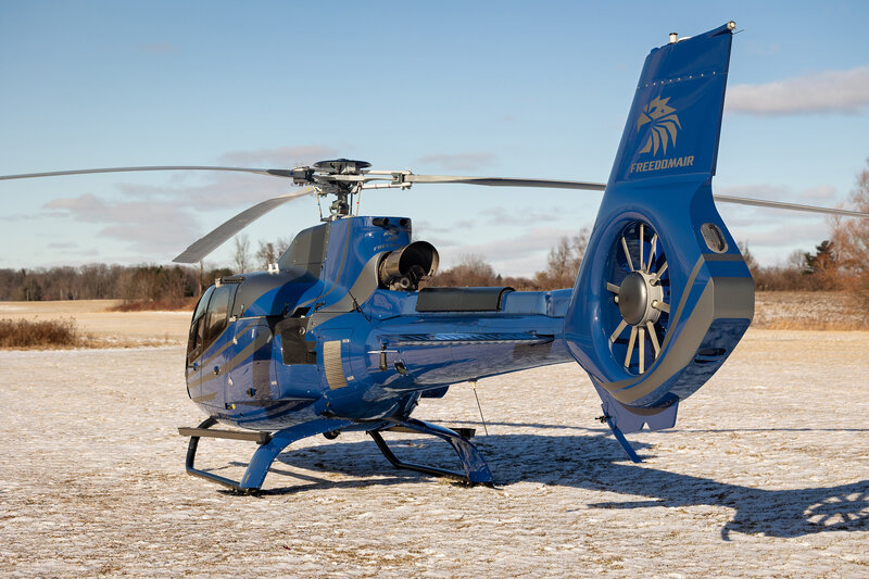 blue airbus ec130 b4 helicopter flying in sky - high-end private aircraft transport