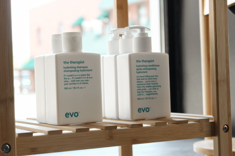 Shampoo bottles next to conditioner bottles on a salon retail shelf