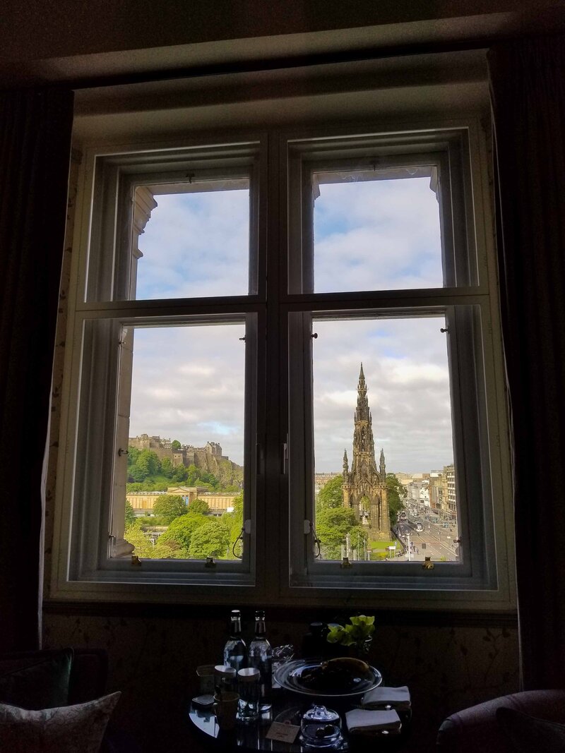 View of Edinburgh Castle and the Scott Monument through a suite window at The Balmoral, Edinburgh, Scotland, an elegant choice for luxury hotel bookings in the heart of the city ©Stephanie Dosch | theViatrix Luxury Travel