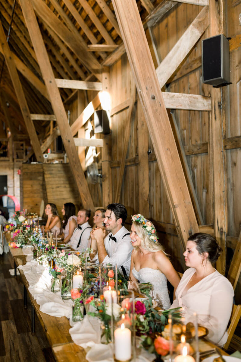 Bride and groom listen to wedding toasts during their wedding reception