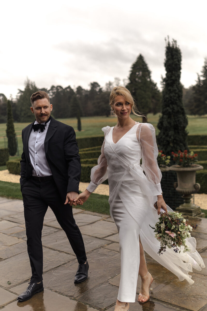 Wedding photographer captures couple taking a stroll hand in hand at their french chateau wedding.