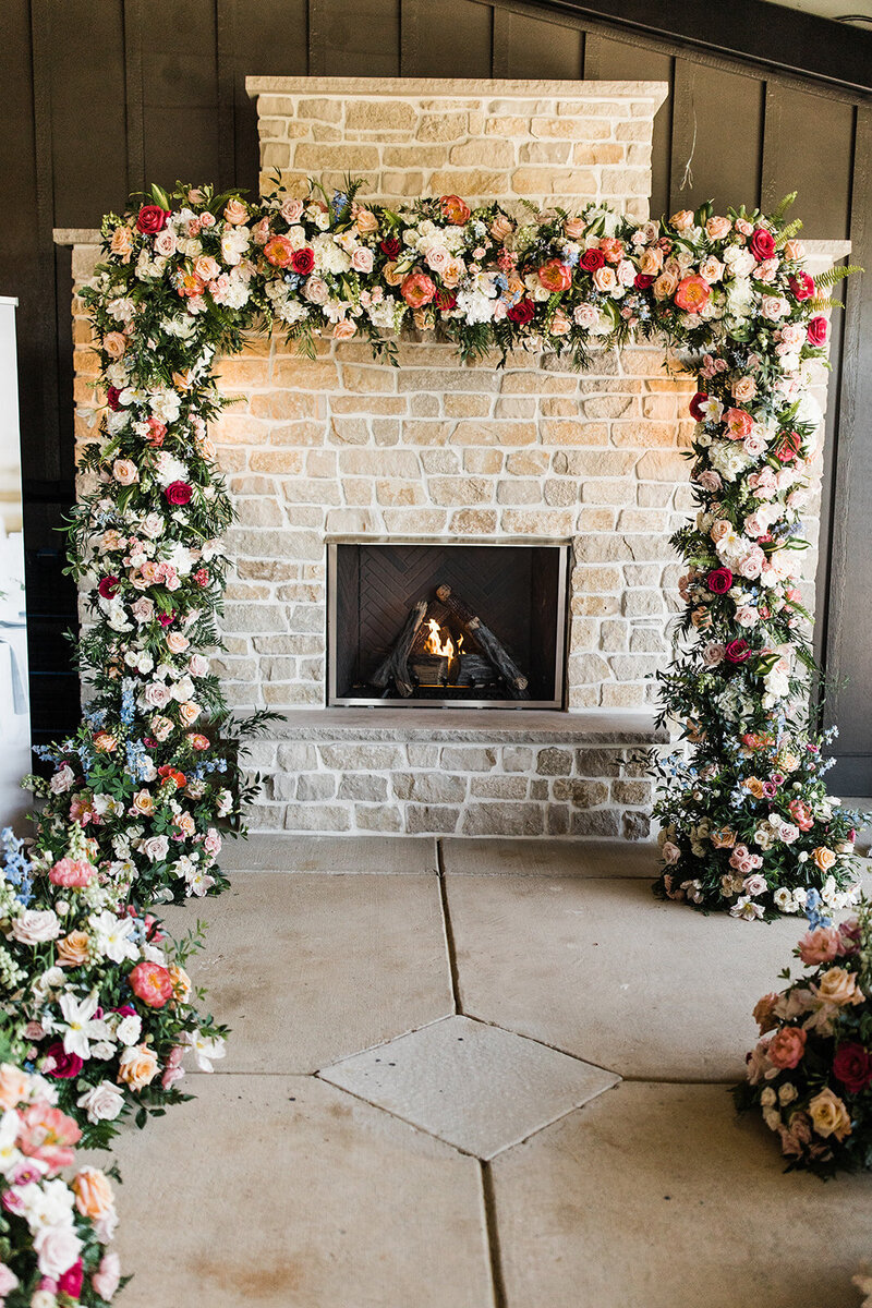 Beautiful floral display for ceremony down the aisle and on a stone fireplace