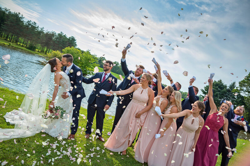 Bridal party cheering and throwing rose petals.