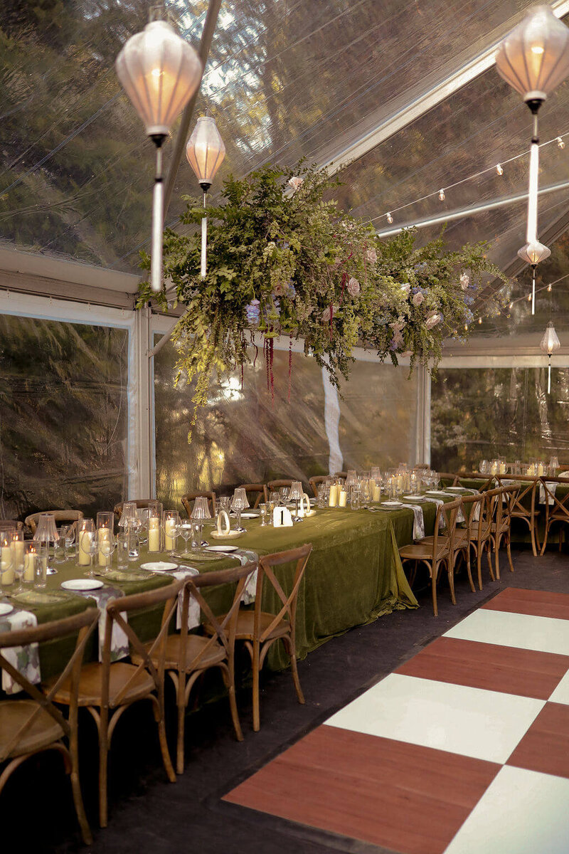 Luxury backyard wedding in see through tent with hanging floral installation and candles. 