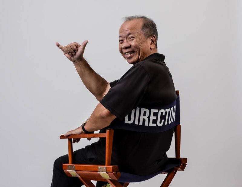 Portrait of Carlton Saito giving a shaka.