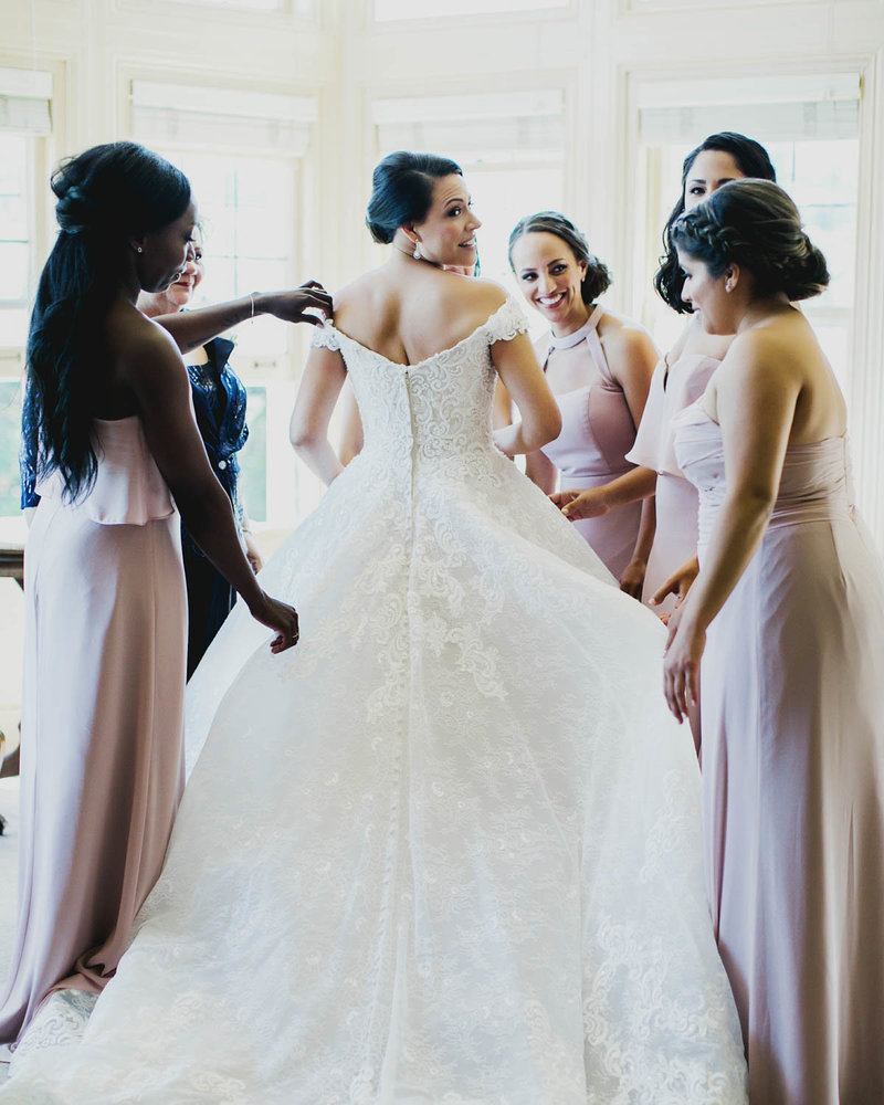 Bridesmaids surround Bride as they help her get ready