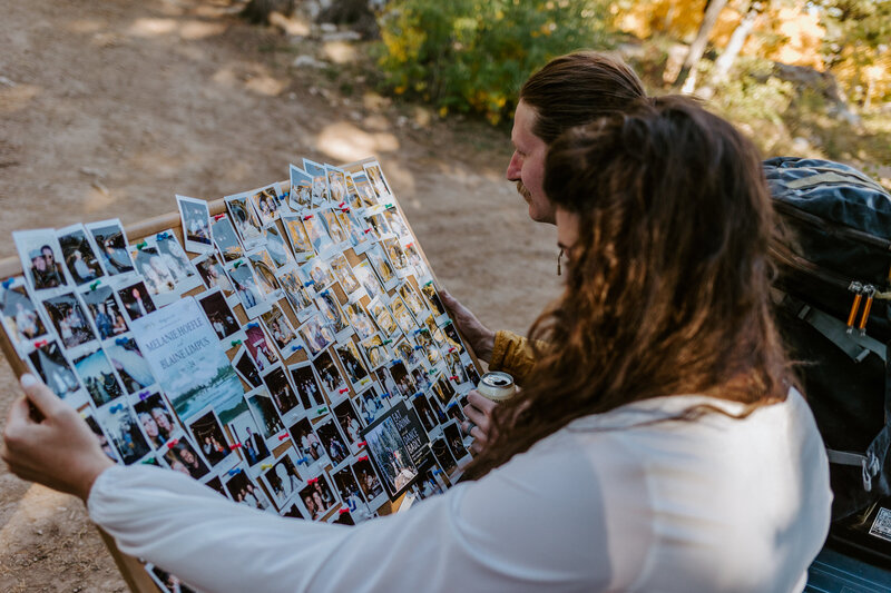 Couple looks at their wedding polaroids after their wedding