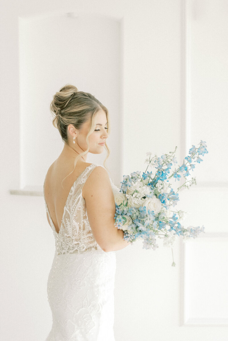 Chateau Joli - Bride with white lace dress at Chateau Joli with blue bouquet