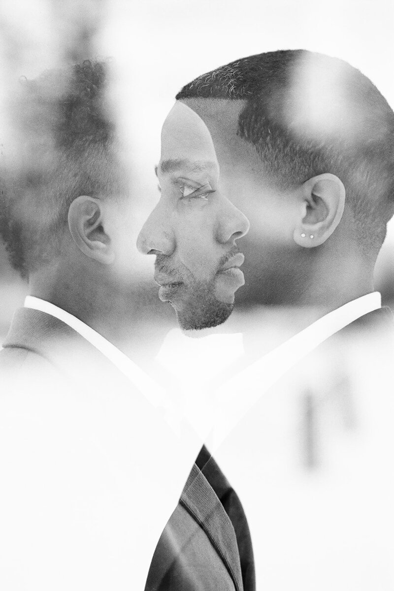 artistic portrait on wedding day of grooms looking at each other in the adirondacks