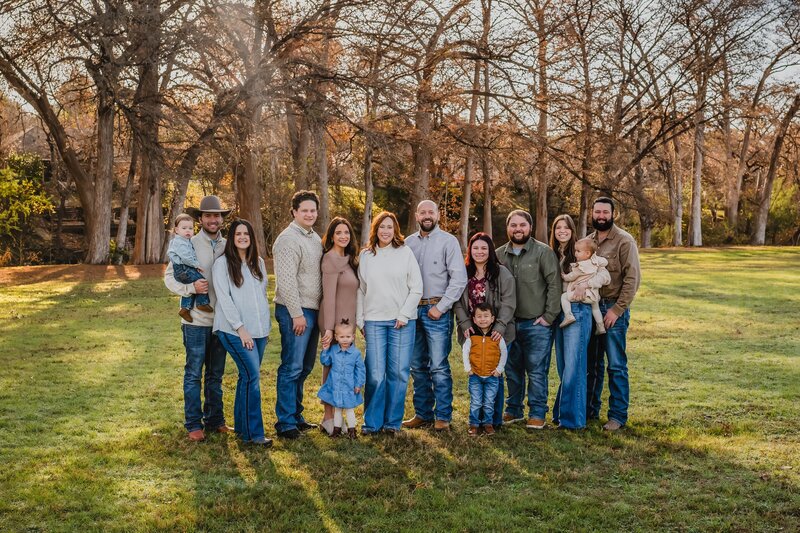Extended family posing together in field in New Braunfels  during lifestyle photography session.