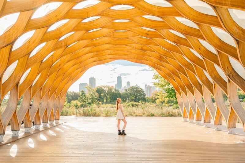 Girl in white dress and black boots under the honeycomb structure at Lincoln Park in downtown Chicago