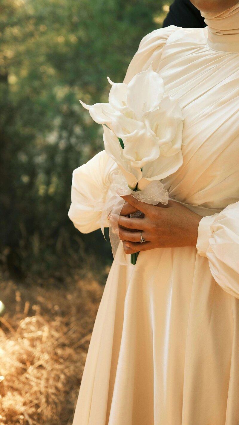 Faceless bride holds white flowers representing the inclusion of florists as bridal show vendors at the crush collective.