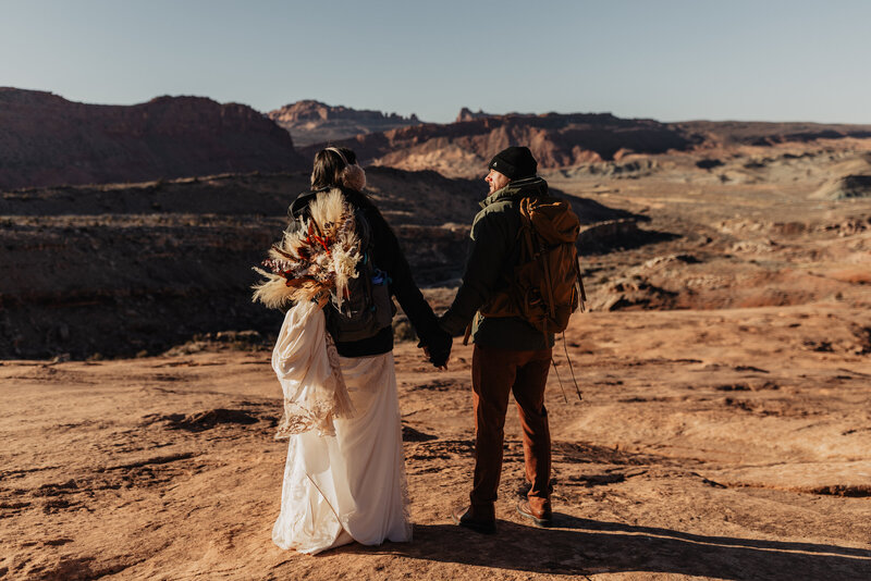 Couple elopes in Moab, Utah with hiking backpacks