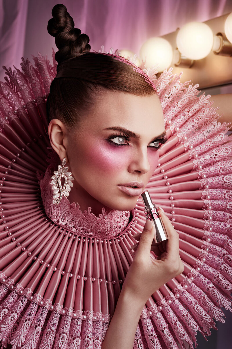 Side profile portrait of Ashley in a pink, high-fashion ruffled outfit, with bold makeup, captured by Ylva Erevall.