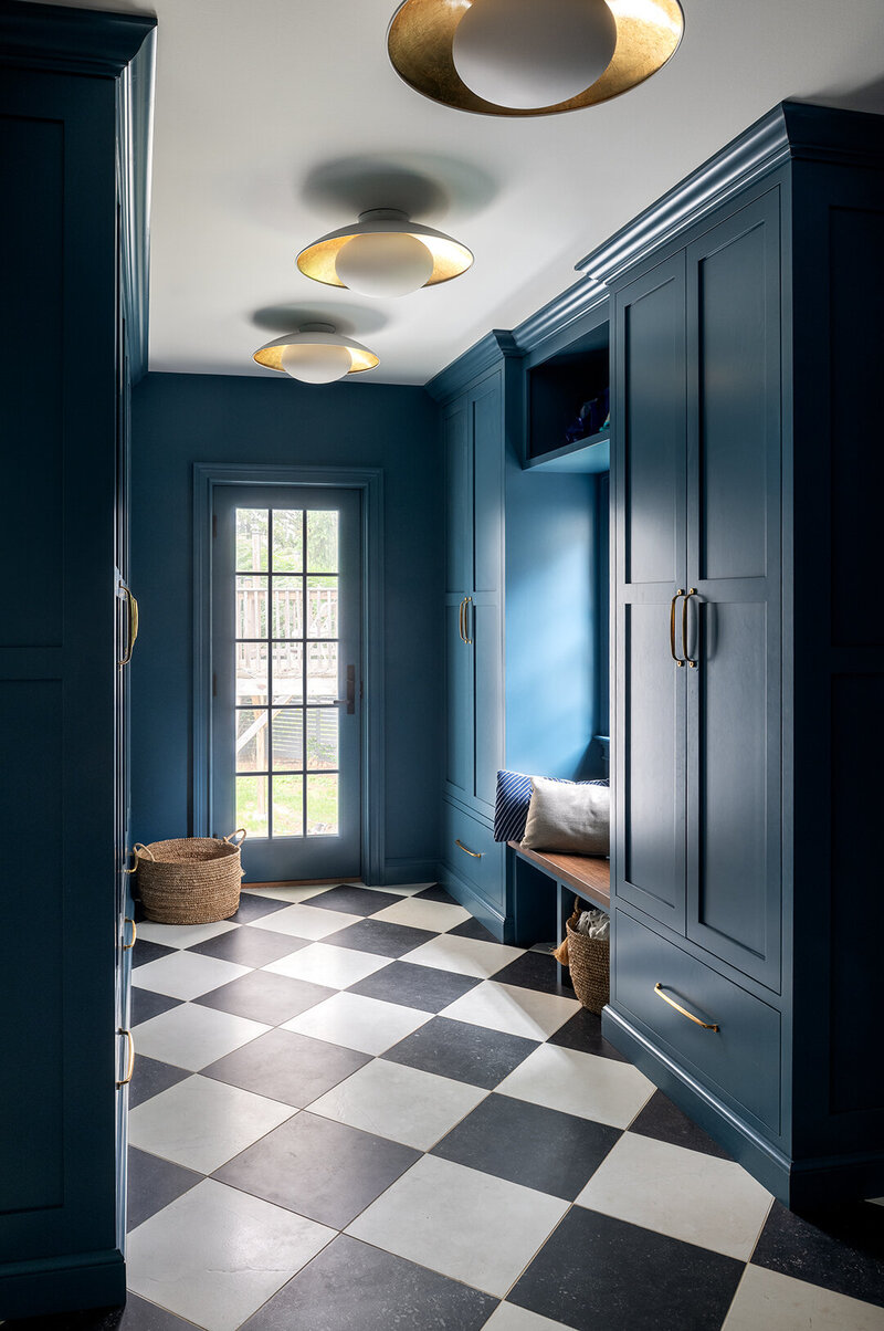 mudroom with checkered tiles and blue green walls